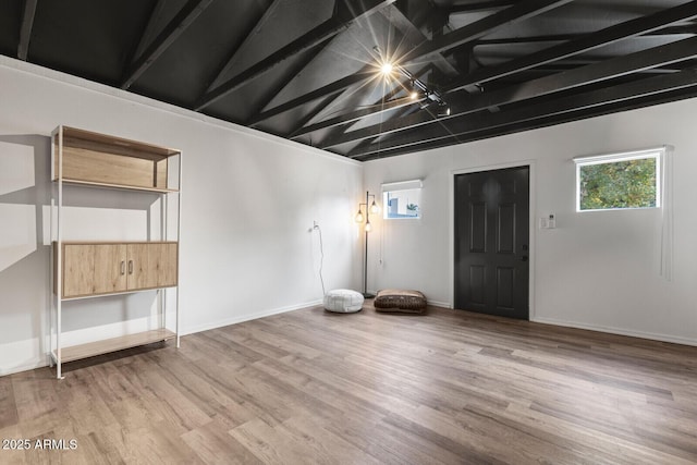 interior space featuring light hardwood / wood-style floors and lofted ceiling