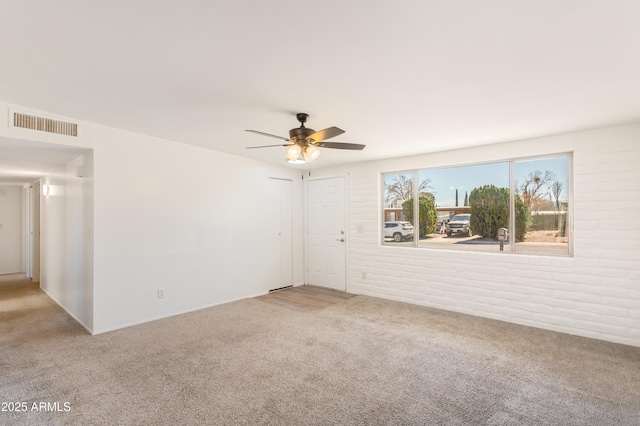 empty room featuring visible vents, ceiling fan, and light carpet