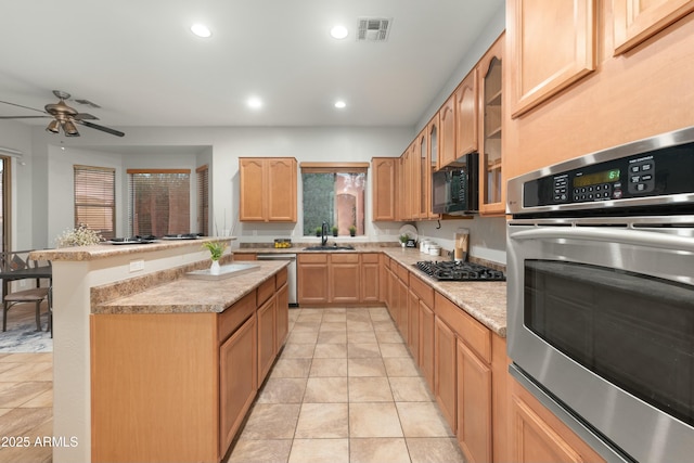 kitchen featuring visible vents, stainless steel appliances, light brown cabinets, a sink, and recessed lighting