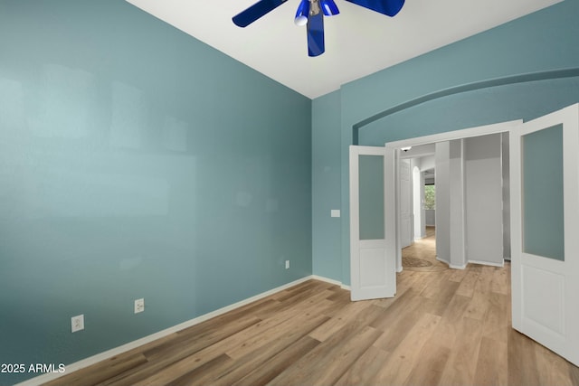 spare room with baseboards, a ceiling fan, and wood finished floors