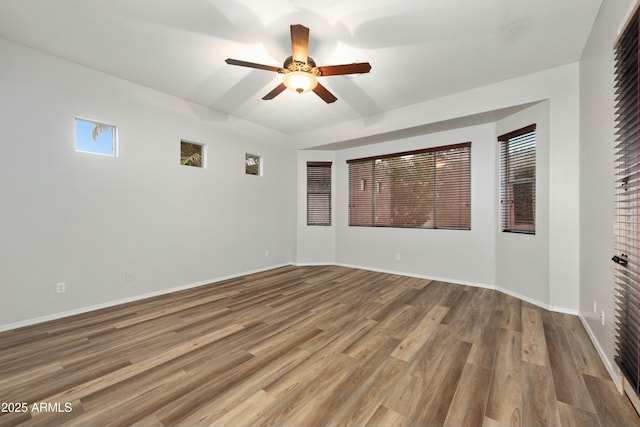 spare room with ceiling fan, baseboards, and wood finished floors