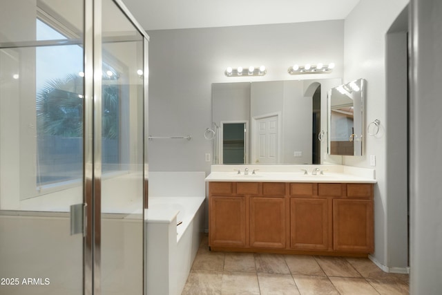 full bathroom featuring a sink, double vanity, a shower stall, and a bath