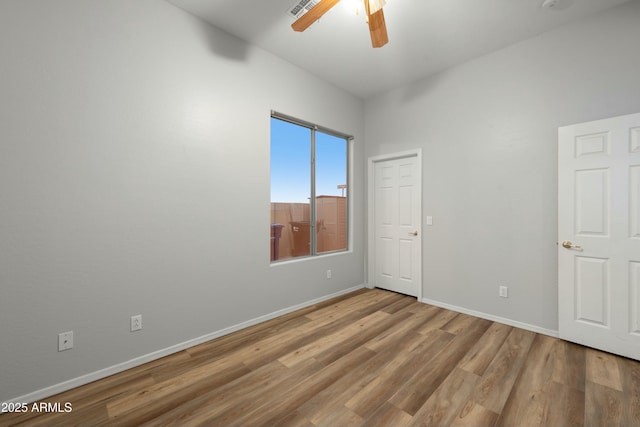 unfurnished room featuring ceiling fan, baseboards, and wood finished floors