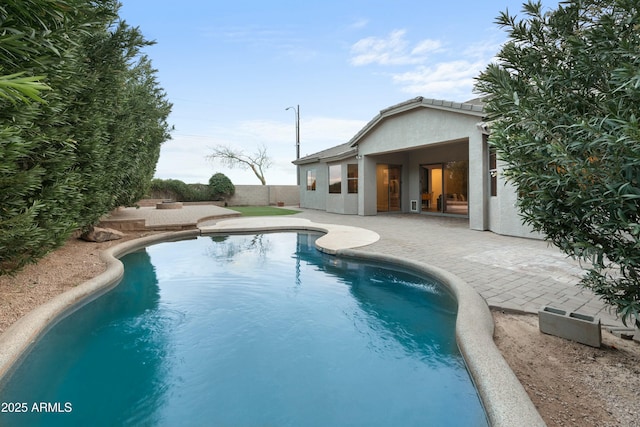 outdoor pool featuring a patio and fence