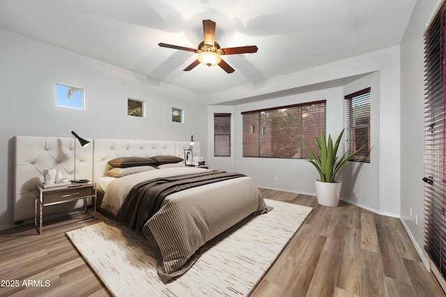 bedroom with ceiling fan, baseboards, and wood finished floors