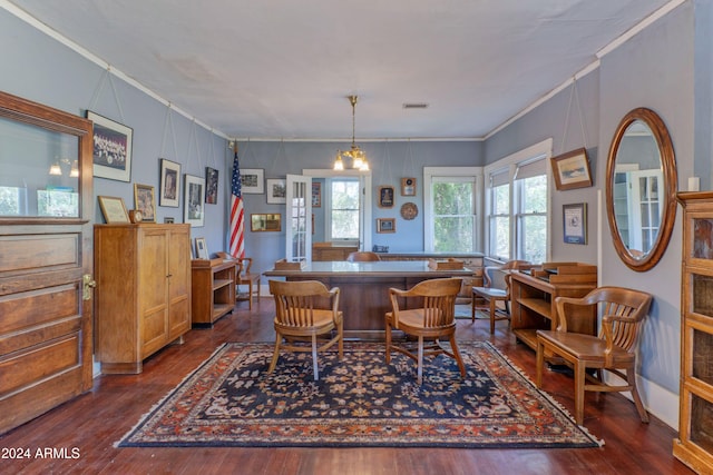 dining area featuring crown molding, dark hardwood / wood-style flooring, and an inviting chandelier