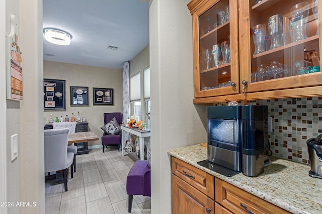 kitchen with decorative backsplash and light stone counters