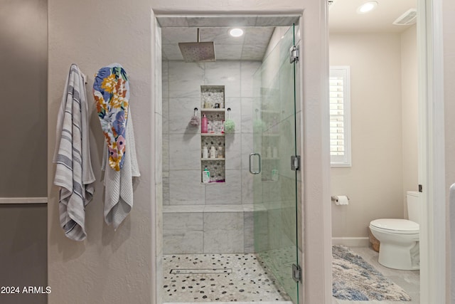 bathroom with toilet and a shower with shower door