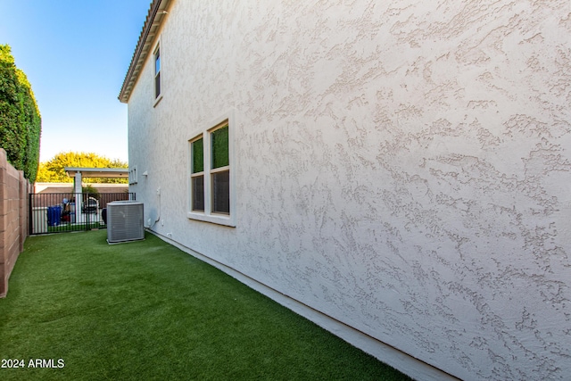 view of home's exterior with a yard and central air condition unit