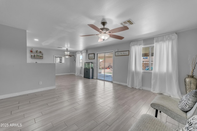 23693 W Grove St, Buckeye, AZ 85326 - unfurnished living room featuring ceiling fan, baseboards, and light wood-style floors