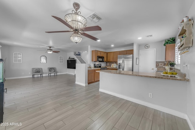 23693 W Grove St, Buckeye, AZ 85326 - kitchen featuring appliances with stainless steel finishes, ceiling fan, open floor plan, recessed lighting, and brown cabinets