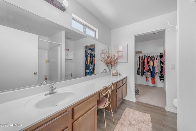 23693 W Grove St, Buckeye, AZ 85326 - bathroom featuring toilet, wood finished floors, vanity, a shower, and a spacious closet