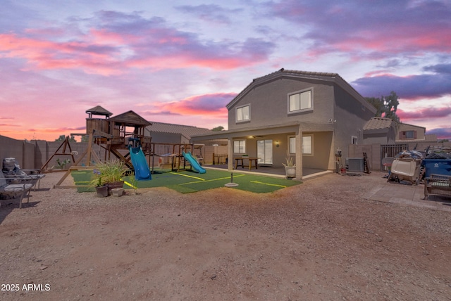 23693 W Grove St, Buckeye, AZ 85326 - playground at dusk with a playground, a patio, a fenced backyard, and central air condition unit