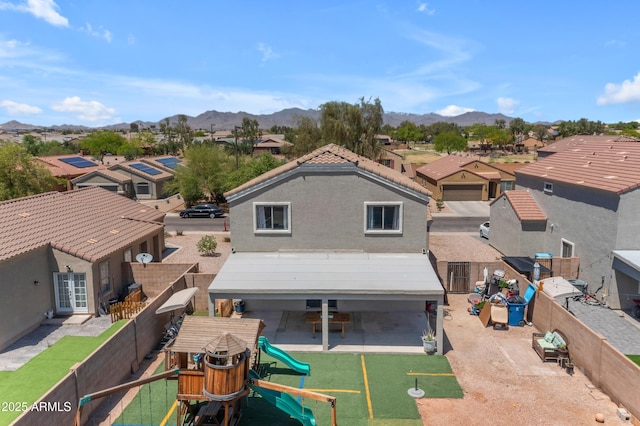 23693 W Grove St, Buckeye, AZ 85326 - rear view of house featuring a residential view, a playground, a fenced backyard, and a mountain view