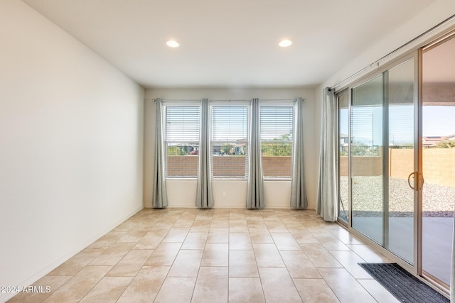 empty room with a healthy amount of sunlight and light tile patterned flooring