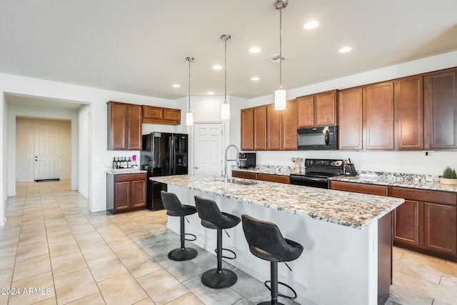 kitchen with black appliances, a center island with sink, sink, and hanging light fixtures