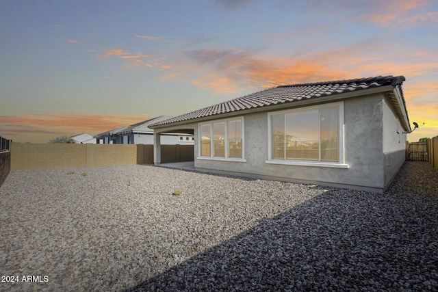 back house at dusk with a patio