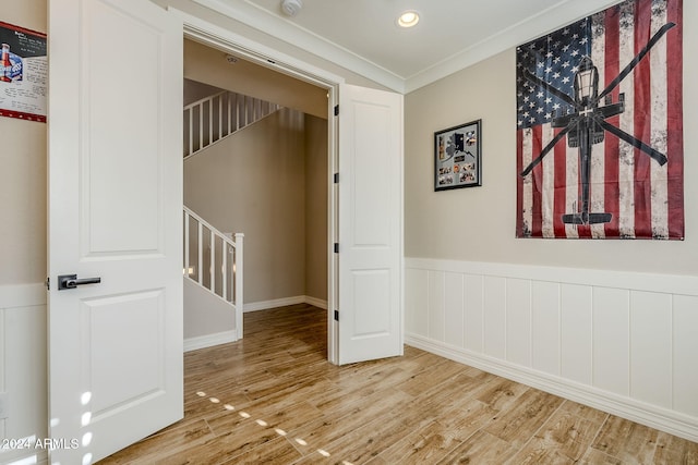 hallway with hardwood / wood-style floors and ornamental molding