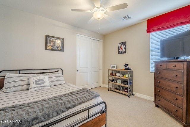 bedroom featuring ceiling fan, a closet, and light carpet