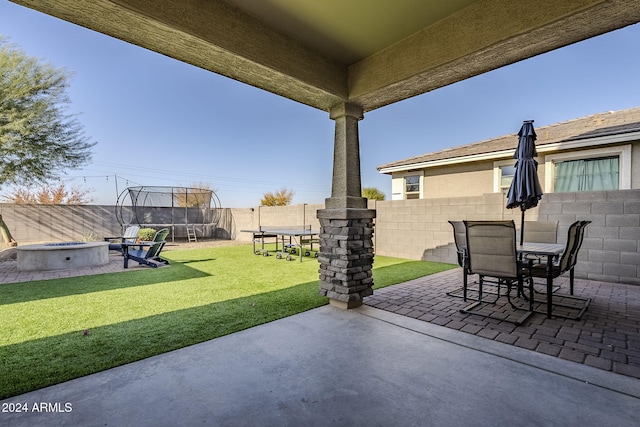 view of patio / terrace featuring a trampoline and a fire pit