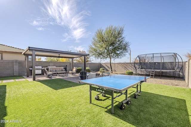 view of yard featuring outdoor lounge area, a patio, and a trampoline