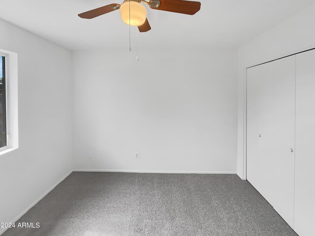 carpeted spare room featuring ceiling fan