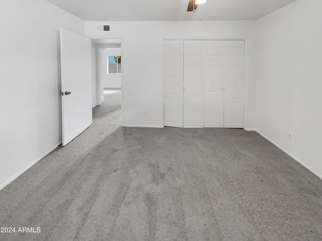 unfurnished bedroom with a closet, carpet floors, and ceiling fan