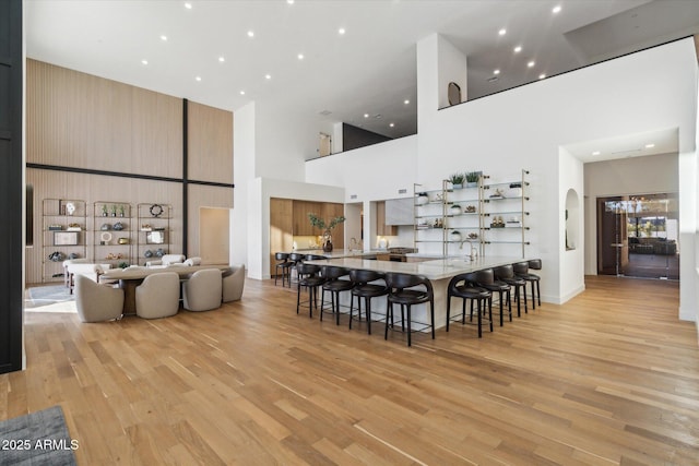 dining space featuring a high ceiling and light hardwood / wood-style flooring