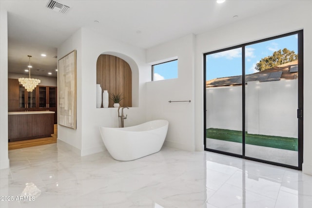 bathroom featuring a bathtub and a chandelier