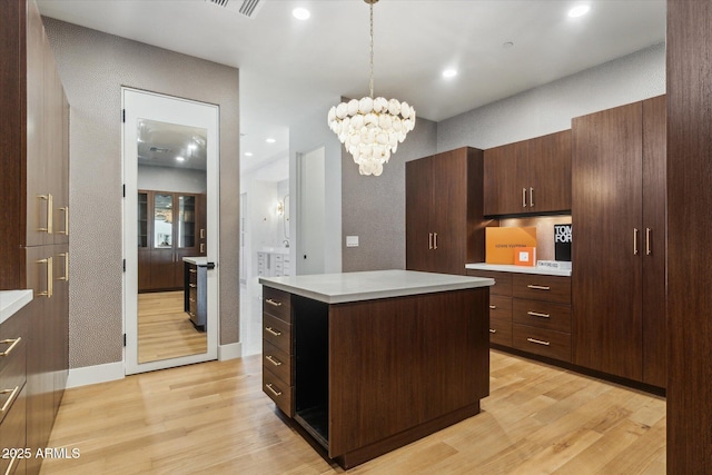 kitchen featuring a center island, a chandelier, light wood-type flooring, and hanging light fixtures