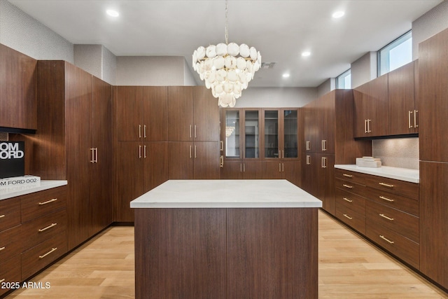 spacious closet with an inviting chandelier and light hardwood / wood-style floors