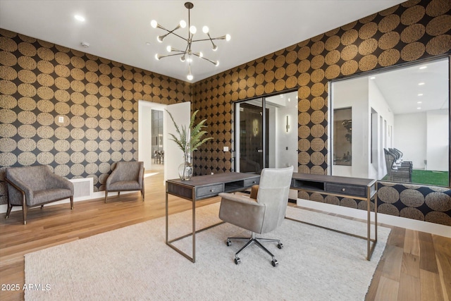 home office featuring an inviting chandelier and hardwood / wood-style flooring