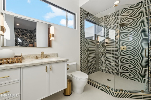 bathroom with toilet, a tile shower, and vanity