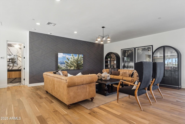 living room with light hardwood / wood-style flooring and an inviting chandelier