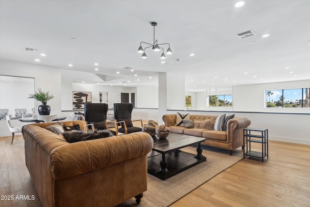 living room with an inviting chandelier and light wood-type flooring