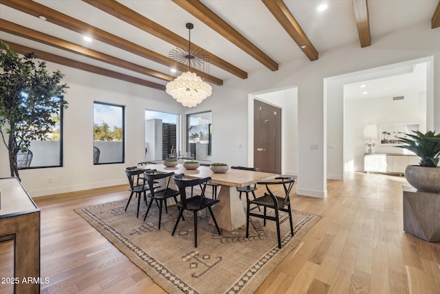 dining space featuring light hardwood / wood-style floors, an inviting chandelier, and beamed ceiling