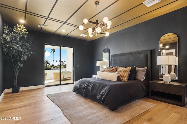 bedroom featuring an inviting chandelier and light hardwood / wood-style flooring