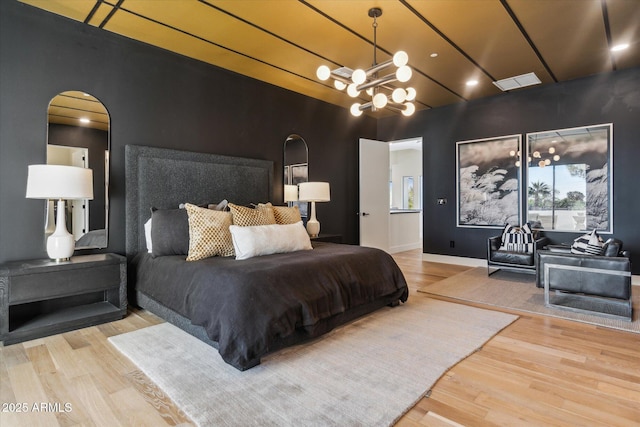 bedroom with a notable chandelier and wood-type flooring