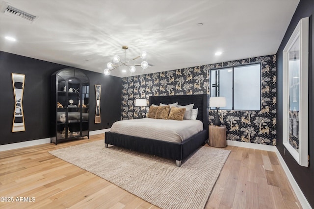 bedroom with a chandelier and wood-type flooring