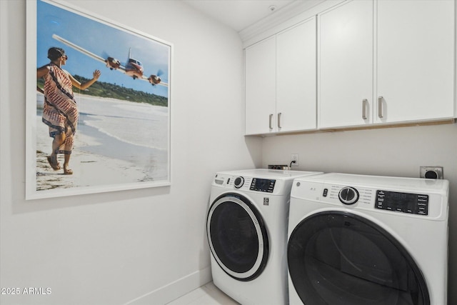 clothes washing area featuring washer and dryer and cabinets