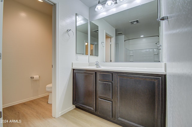 bathroom with vanity, toilet, and wood-type flooring