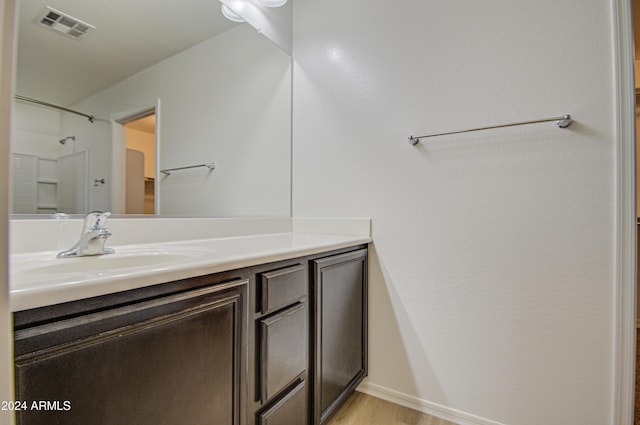 bathroom with a shower, vanity, and wood-type flooring