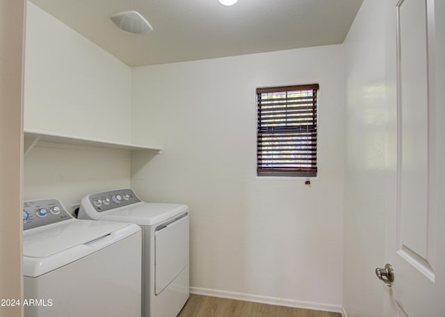 washroom featuring washer and clothes dryer and light hardwood / wood-style flooring