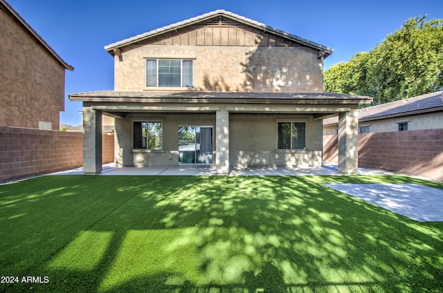 rear view of house featuring a patio and a lawn