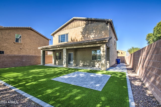 back of property with a yard and a patio area