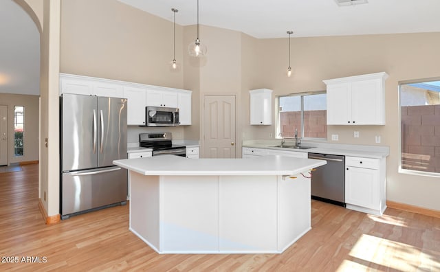 kitchen with sink, decorative light fixtures, a center island, white cabinetry, and appliances with stainless steel finishes