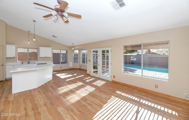 kitchen featuring decorative light fixtures, a center island, and white cabinetry