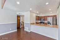 kitchen featuring kitchen peninsula, stainless steel appliances, and dark hardwood / wood-style floors