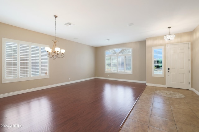 foyer entrance featuring an inviting chandelier and wood-type flooring