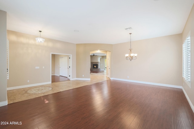 unfurnished living room with light hardwood / wood-style flooring, a wealth of natural light, and a chandelier